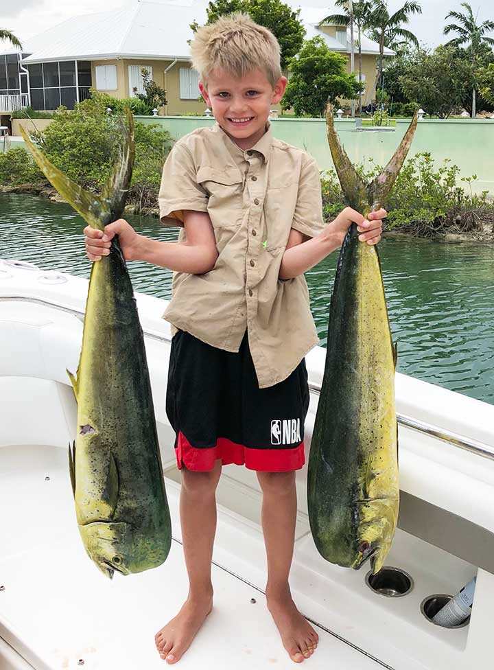 kid catches two giant manful mahi mahi