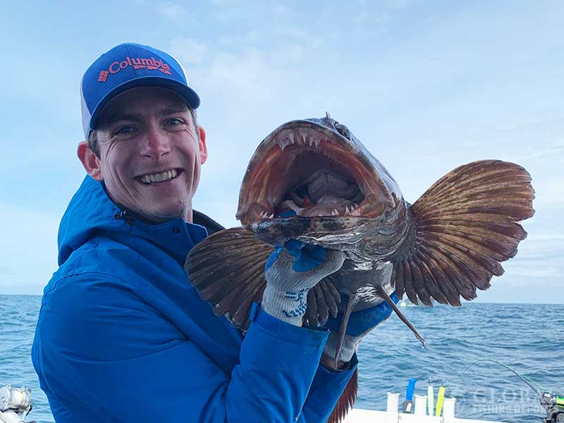 captain cody showing the teeth of a large lingcod