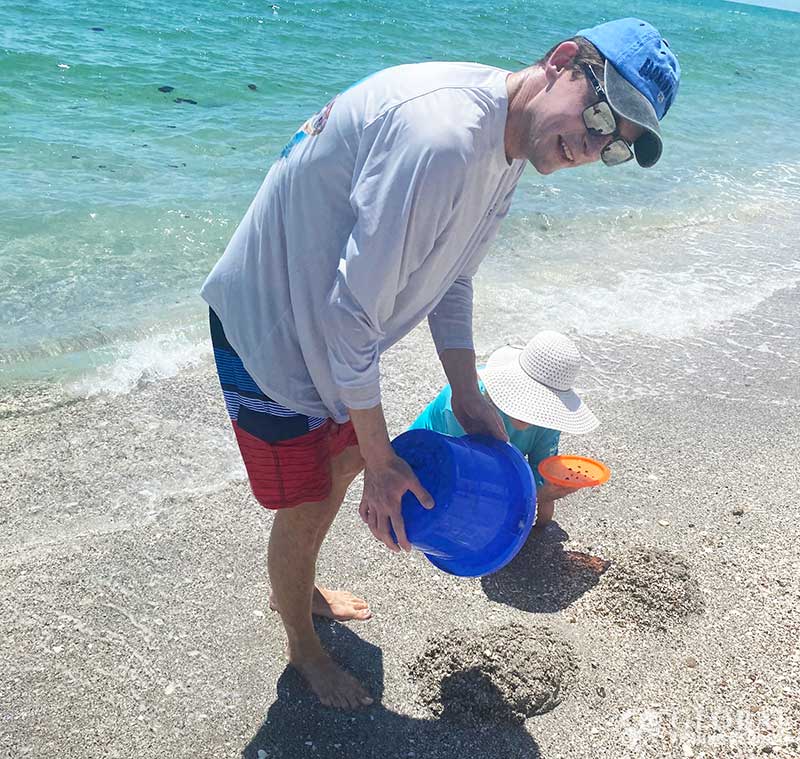 Dumping sand so the waves can wash over it exposing shark teeth