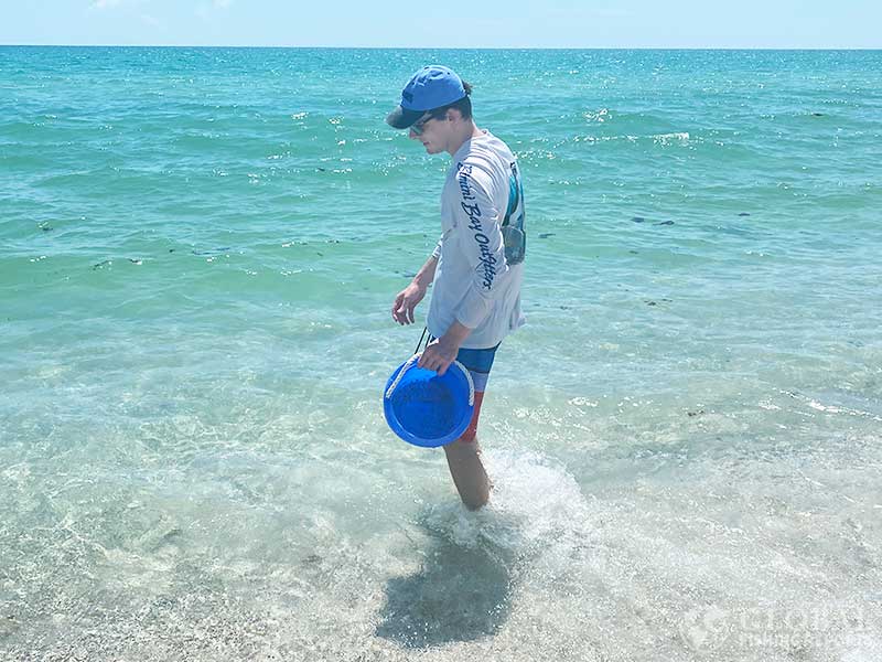 Using a bucket to scoop sand in deep water